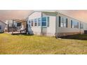 Single-wide manufactured home with deck and stone siding at 1296 Skyline Dr, Tavares, FL 32778
