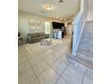 Open living room with tile floors, gray couch, and kitchen views at 1478 Garden Arbor Ln, Orlando, FL 32824