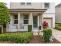 Inviting front porch with white railings, a teal door, and landscaping at 1812 Sandy Park Trl, Kissimmee, FL 34747