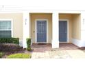 Two-story townhome with gray doors and manicured landscaping at 215 Annabelle Way, Davenport, FL 33837