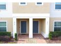 Two-story townhome with gray doors and a brick walkway at 215 Annabelle Way, Davenport, FL 33837