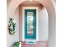 Inviting arched entrance with a teal front door featuring decorative glass and a 'Welcome' mat at 2285 Palm Tree Dr, Kissimmee, FL 34759
