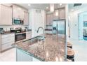 Modern kitchen with stainless steel appliances, gray cabinets, and a granite-topped island with seating at 2285 Palm Tree Dr, Kissimmee, FL 34759