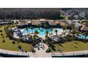 Aerial view of a luxurious community pool area with palm trees, lounge chairs, and a splash pad at 2449 Varenna Loop, Kissimmee, FL 34741