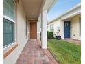 Brick paved walkway to the front door with a brown door at 2451 Datura Loop, St Cloud, FL 34772