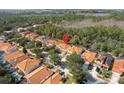 An aerial view showcases a neighborhood of homes in a scenic area with lush greenery at 2818 Roccella Ct, Kissimmee, FL 34747