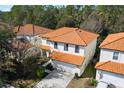 Aerial view of a two-story home featuring a classic tile roof and lush surrounding trees at 2818 Roccella Ct, Kissimmee, FL 34747