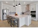 Modern kitchen with white cabinets, large island, and stainless steel appliances at 3055 Prospect Trl, St Cloud, FL 34771