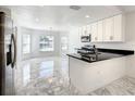 Bright kitchen with white cabinetry, stainless steel appliances, and a seamless transition into the dining area at 438 Jay Ct, Kissimmee, FL 34759
