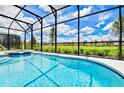 Relaxing screened-in pool and spa with a view of lush greenery at 7638 Oakmoss Loop, Davenport, FL 33837