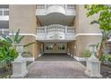 Elegant condo building entrance featuring stone accents, decorative urns, and a covered walkway at 7658 Whisper Way # 202, Reunion, FL 34747