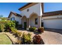 Inviting entryway with arched columns and lush landscaping at 9067 Arbors Edge Trl, Windermere, FL 34786