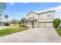 Beautiful two-story home featuring a well-manicured lawn, brick driveway and a welcoming covered porch at 9786 Lake District Ln, Orlando, FL 32832