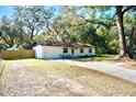 White brick ranch home with a large yard and mature trees at 1080 Springbank Ave, Orange City, FL 32763