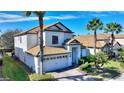 Two-story home with tile roof, white exterior, and a two-car garage at 1320 Moss Creek Ln, Davenport, FL 33836