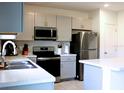 Modern kitchen with stainless steel appliances and light gray cabinets at 196 Albany Dr, Kissimmee, FL 34759