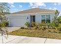 One-story home with light-blue exterior, brick driveway, and landscaped lawn at 2124 Live Oak Lake Rd, St Cloud, FL 34771