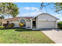 Single-story home with attached garage and well-maintained lawn at 2302 Aberdeen Ct, Kissimmee, FL 34743
