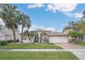 One story house with a tile roof, palm trees, and a brick driveway at 2404 Huron Cir, Kissimmee, FL 34746