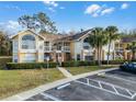 Condo building exterior with landscaping and parking at 2452 Sweetwater Club Cir # 27, Kissimmee, FL 34746