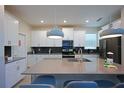 Bright kitchen features white cabinets, stainless steel appliances, and a large center island at 2797 Bookmark Dr, Kissimmee, FL 34746