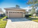 Tan two-car garage with brick paver driveway at 301 Anastasia Dr, Kissimmee, FL 34759