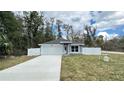 Lovely single story home with gray and white paint, two car garage, and white fence at 3839 Se 132Nd Pl, Belleview, FL 34420