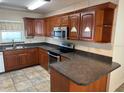 L-shaped kitchen with wood cabinets and dark countertops at 4607 Pine Lake Dr, St Cloud, FL 34769