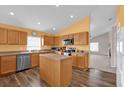 Open kitchen with island, wood cabinets, and stainless steel appliances at 4702 Ashurst St, Kissimmee, FL 34758
