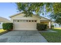 House exterior showcasing a two-car garage and neat landscaping at 8077 Roaring Creek Ct, Kissimmee, FL 34747