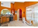 Kitchen with wood cabinets, black appliances, and orange walls at 8077 Roaring Creek Ct, Kissimmee, FL 34747