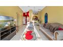 Bright living room featuring a comfortable sofa, armchair, and a large TV at 8077 Roaring Creek Ct, Kissimmee, FL 34747