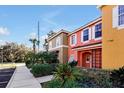 Townhome exterior showcasing a vibrant peach facade and walkway at 8552 Crystal Cove Loop, Kissimmee, FL 34747