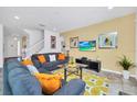 Living room with gray couches, orange pillows, and a large TV at 5192 Oakbourne Ave, Davenport, FL 33837