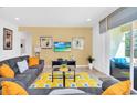 Living room with gray couches, orange throw pillows, and a glass coffee table at 5192 Oakbourne Ave, Davenport, FL 33837