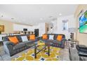 Spacious living room with gray sofas, orange pillows, and a large TV at 5192 Oakbourne Ave, Davenport, FL 33837
