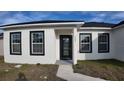 Inviting home entrance featuring a black front door, crisp white walls, and black trimmed windows at 1321 Congo Dr, Kissimmee, FL 34759