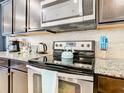 Modern kitchen with stainless steel appliances and granite counters at 1610 Lima Ave, Kissimmee, FL 34747