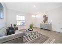 Living room with gray sofa, glass coffee table, and decorative rug at 1809 E Coriander Dr, Kissimmee, FL 34759