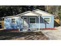 Newly renovated light blue house with white trim, grey walkway, and red mulch at 217 W Chelsea St, Deland, FL 32720