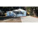 Newly renovated light blue house with white trim and a gravel driveway at 217 W Chelsea St, Deland, FL 32720