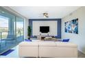 Bright living room with white sectional sofa, large TV, and balcony access at 4731 Clock Tower Dr # 206, Kissimmee, FL 34746