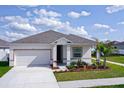 Newly built home with gray roof and landscaping at 566 Pawnee Ct, Haines City, FL 33844