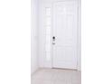 White front door with glass panels and keyless entry at 566 Pawnee Ct, Haines City, FL 33844