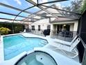 Inviting pool and spa with patio furniture and screened enclosure at 8417 Secret Key Cove, Kissimmee, FL 34747
