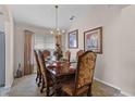 Formal dining room with a wood table, chandelier, and decorative artwork at 8614 La Isla Dr, Kissimmee, FL 34747