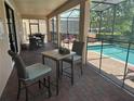 View of covered patio with dining and lounge areas, as well as a clear view of the sparkling pool and relaxing jacuzzi at 9158 Scramble Dr, Davenport, FL 33896