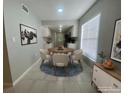 Bright dining room with adjacent kitchen, white cabinets, and modern lighting at 1014 Plantation Dr # A9, Kissimmee, FL 34741