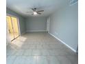 Spacious living area with tile flooring, a modern ceiling fan, and access to an outdoor lanai through sliding glass doors at 1014 Plantation Dr # A9, Kissimmee, FL 34741