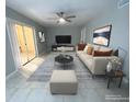 Cozy living room featuring a modern ceiling fan, stylish decor, and sliding glass doors to the lanai at 1014 Plantation Dr # A9, Kissimmee, FL 34741